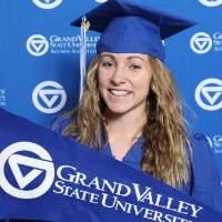 A upcoming graduate poses with GV flag at GradFest